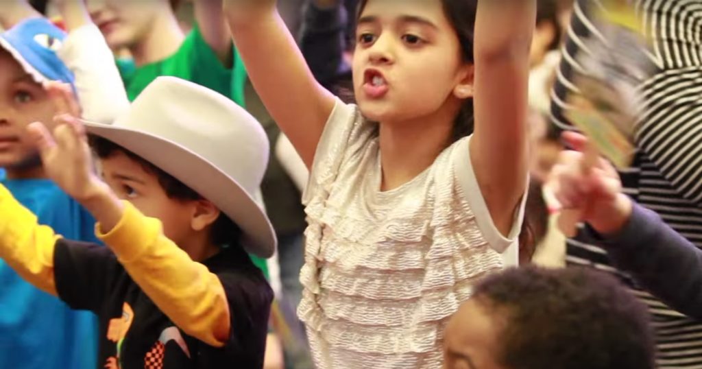 Children sing and raising hands